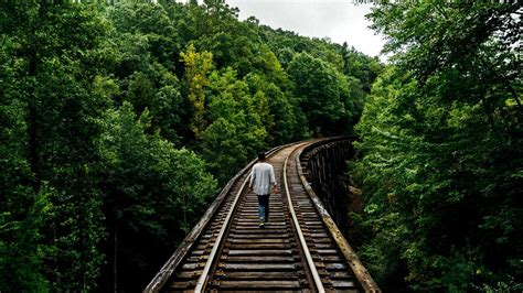Download wallpaper 1366x768 railway, man, walk, trees tablet, laptop hd ...