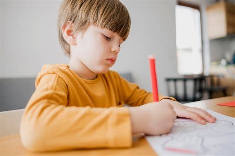 Vista lateral da criança desenhando em casa | Foto Grátis