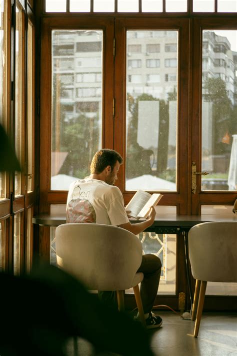 Man Sitting on Chairs and Reading · Free Stock Photo