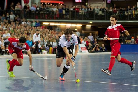 Men playing indoor field hockey
