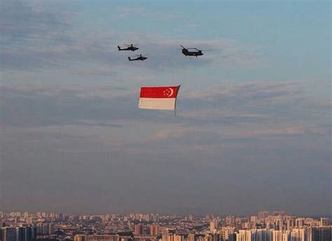 新加坡举行国庆庆典 Singapore National Day Parade 彩排，一架悬挂着新加坡国旗的 CH-47 直升机在两架 AH ...