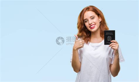 在家拿着美国护照的年轻女人开心地笑着做好手势高清图片下载-正版图片505334679-摄图网