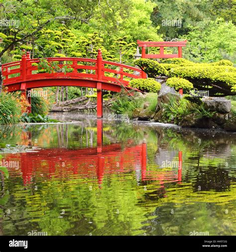 Red bridge over water in Japanese garden Stock Photo - Alamy