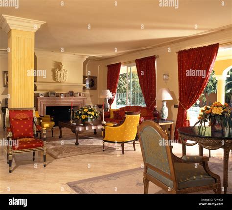Red curtains and colourful chairs and sofa in Spanish living room Stock ...
