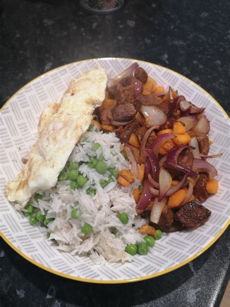 Quorn pieces marinated & stir fried with red onion and carrots, rice, peas and two runny fried ...