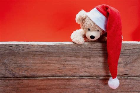 Teddy bear with santa hat red color background | Premium Photo