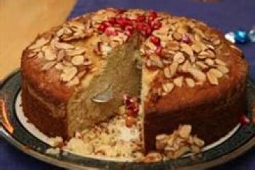 side view of Vaselopita - Greek New Years Cake dusted with powdered sugar with a slice cut out of it