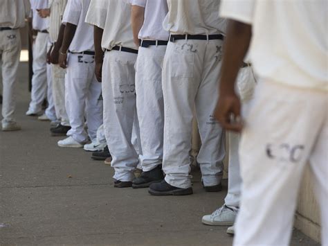Prisoners stand in a crowded lunch line at Elmore Correctional Facility ...