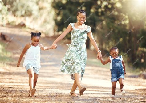 Premium Photo | Happy mother and kids walking in a forest holding hands ...