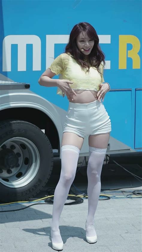 a woman in short white shorts and tights standing next to a blue bus ...