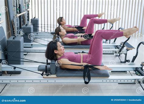 Three Asian Women in Pink Sportswear Doing Pilates Exercises with a ...