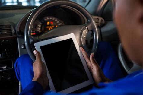 Mechaniker mit digitalen Tablet in Auto | Kostenlose Foto