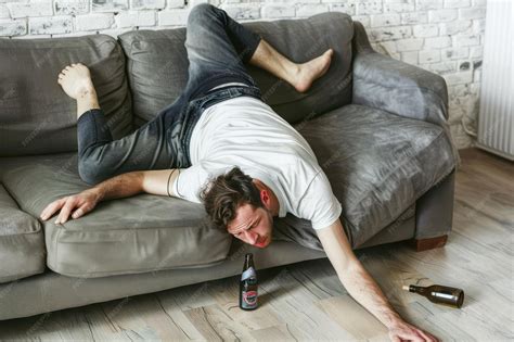 Drunk Young Handsome Man Resting on Couch in the Living Room with Head ...