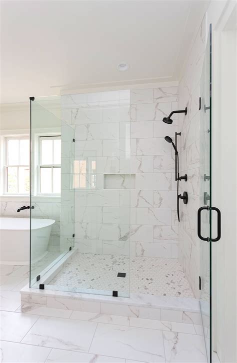 Featuring large marble subway tiles, glass doors, and black hardware ...