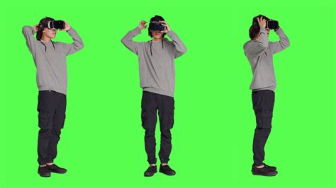 Young guy uses virtual reality tech on camera with full body greenscreen template, using ...