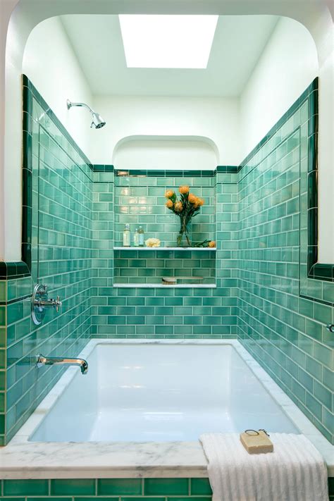 Turquoise tile-clad shower and bathtub alcove with a skylight in a ...