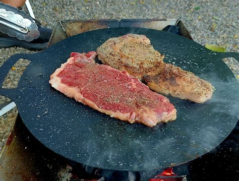 Cooking steaks at camping. Fry steaks in a frying pan at camping ...
