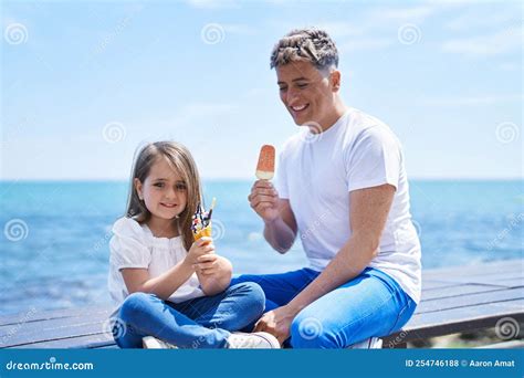 Padre E Hija Comiendo Helados Sentados En Un Banco a Orillas Del Mar ...