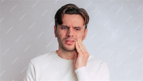 Premium Photo | Portrait of sad young man touching his cheek unhealthy guy pressing sore cheek ...