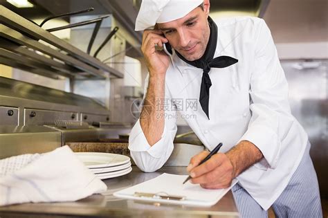 在厨房使用手机时在剪贴板上写作男性职业笔记呼唤专注白人厨师电话沟通工作高清图片下载-正版图片322049764-摄图网