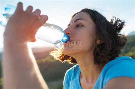 一个女人在山顶喝水女孩解渴疲惫的游客用塑料瓶喝饮料黑发女人嘴高清图片下载-正版图片503540715-摄图网