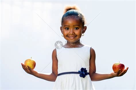 每只手握着苹果的甜美非洲女孩的肖像在光线背高清图片下载-正版图片502514940-摄图网