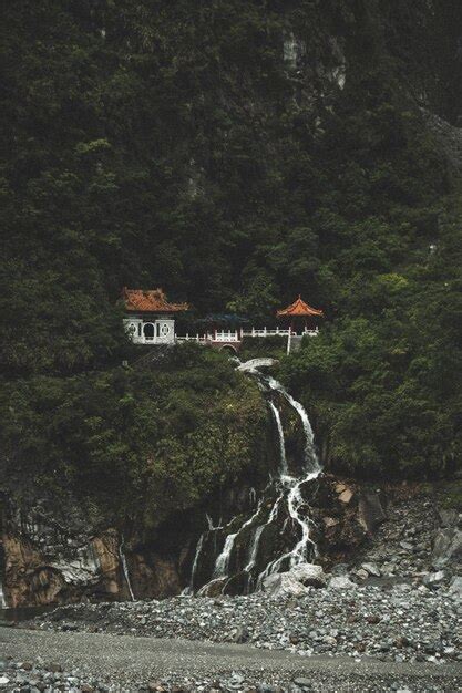 Built structure on rock formation by waterfall | Premium Photo