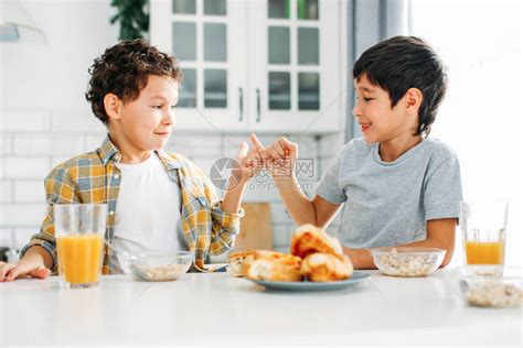 两个兄弟姊妹和真正的兄弟在家里的厨房里吃早高清图片下载-正版图片503989761-摄图网