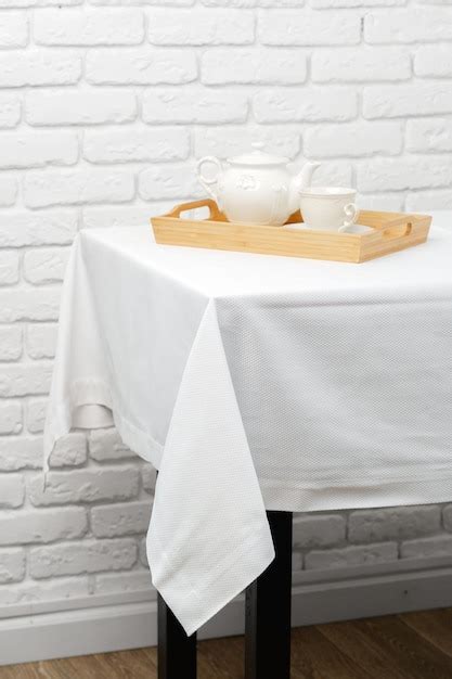 White textured tablecloth draped over black table leg | Premium Photo