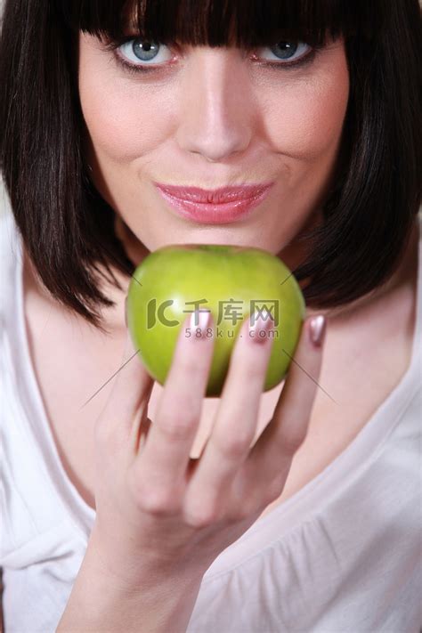 一个拿着青苹果的女人的特写高清摄影大图-千库网
