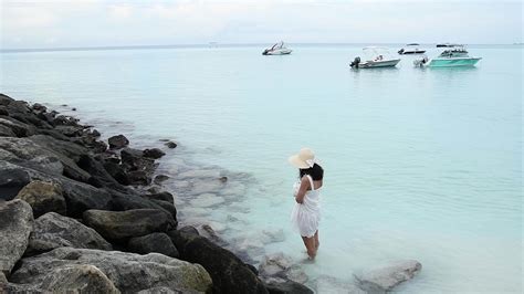 Luxury travel woman in white beachwear sarong walking taking a stroll ...