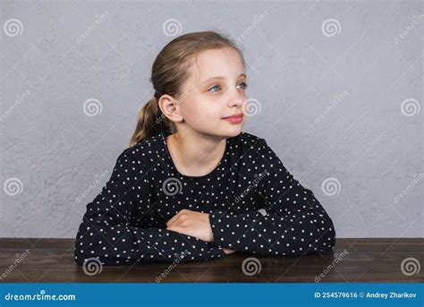 A European Girl is Sitting at the Table Doing Her Homework. Portrait of ...