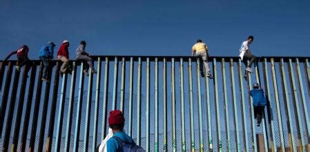 Una veintena de migrantes de la caravana intenta saltar el muro con ...