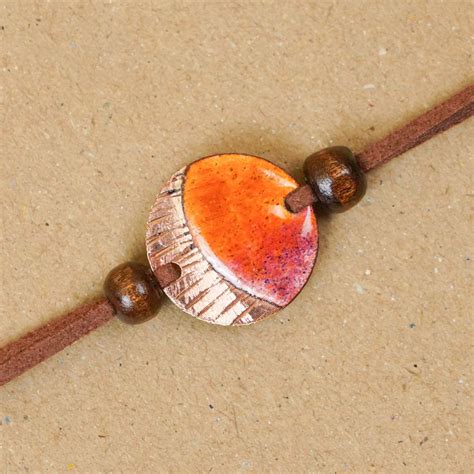 Buy Handmade Ambar Textured Yellow Copper Enamel Rakhi With Chocolates ...