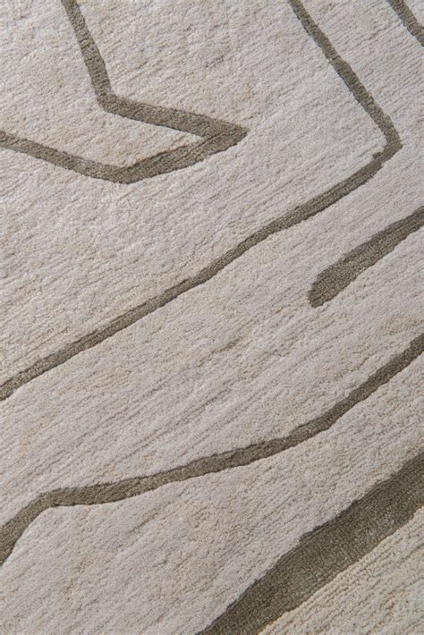 Close-up of a textured rug with wavy lines in beige and brown.