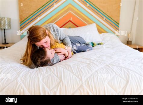 Mother and daughter cuddling on a bed in a kids room