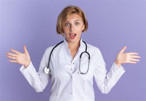 Surpris jeune femme médecin portant une robe médicale avec stéthoscope ...