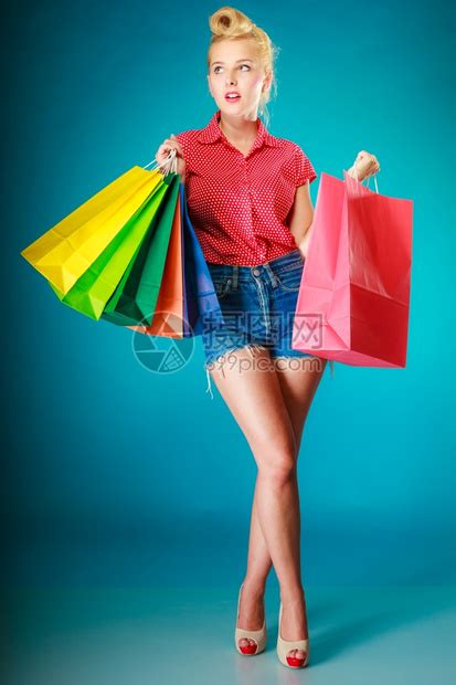 Pinup女孩惊讶于穿旧式服装买衣的女人客户拿着鲜艳的蓝色购物袋零售和销工作室拍摄高清图片下载-正版图片303958791-摄图网