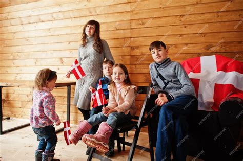 Familia con banderas de dinamarca dentro de una casa de madera viajar a los países escandinavos ...