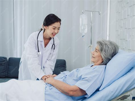 Happy asian elderly senior woman patient in light blue dress lying on ...