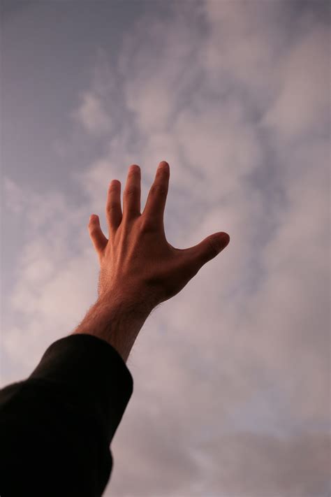 A hand reaching up into the sky to catch a frisbee photo – Free ...