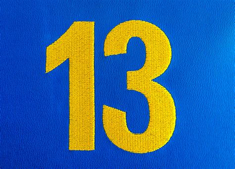 Closeup Of Woven Thirteen 13 Number On Cloth Against Bright Vibrant ...