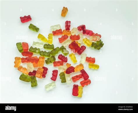 gummy bears of different colors lie on a matte white background ...