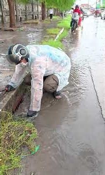 Draining a Flooded Street While Removing Trash in Heavy Rain