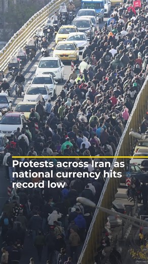 Protests erupted across Iran after the rial plunged to a record low against the US dollar. Demonstrations spread across Tehran and other cities as shopkeepers and students protested rising prices and economic hardship, while the government pledged talks and economic relief. #news #Iran