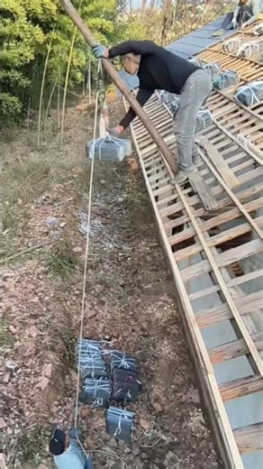 Roof repair work: Hoisting glazed tiles to the roof using guide pulley blocks