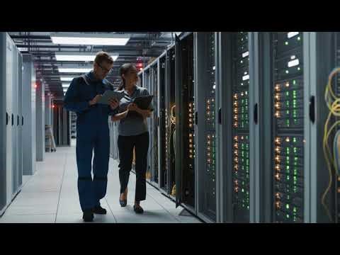 IT team of professionals walking through modern data center server room reviewing data Stock footage