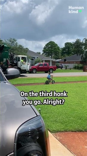 Watch who wins when the garbage truck races a 4-year-old on his bike