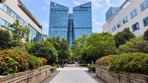 Este paseo verde en Shenzhen lleva hacia dos torres de cristal