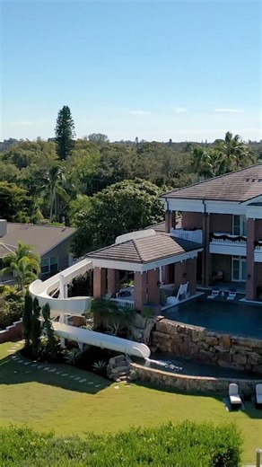 Happy New Year! Natural Rock Infinity-edge Pool with 121-Foot Water Slide starting from the second-floor balcony. #insanepools #lucaslagoons #waterslide | Lucas Lagoons Design